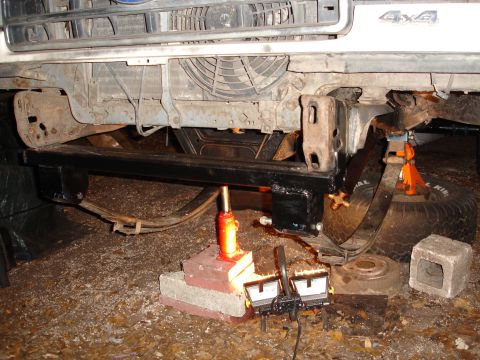 1989 Ford Bronco - Front view of a 1989 Ford Bronco undergoing repairs, showing the suspension and frame with a prominent 4x4 badge.