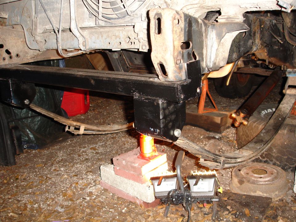 Vehicle frame with jack and support stands, leaf springs visible