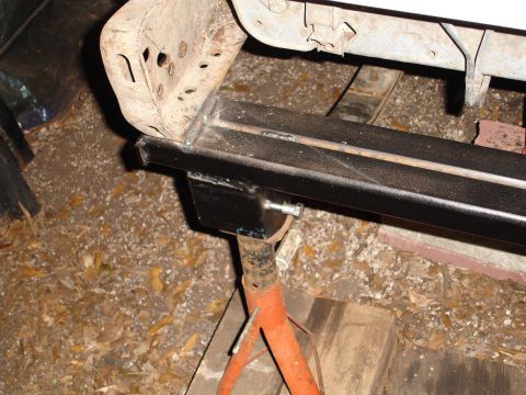 1989 Ford Bronco - Vehicle frame rail being worked on, supported by a jack stand.