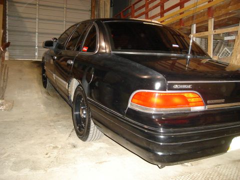 1992 Ford Crown Victoria - Rear quarter view of a black 1992 Ford Crown Victoria parked in a garage.