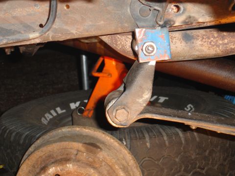 1989 Ford Bronco - Close-up view of a modified suspension component, possibly for off-road use, with a spare tire underneath.