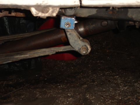 1989 Ford Bronco - Underside view of a vehicle's suspension components, including a leaf spring and shock absorber bracket.