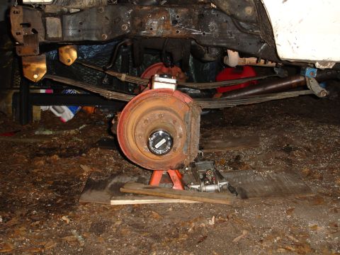 1989 Ford Bronco - Close-up of a vehicle's undercarriage, showing suspension and brake components.