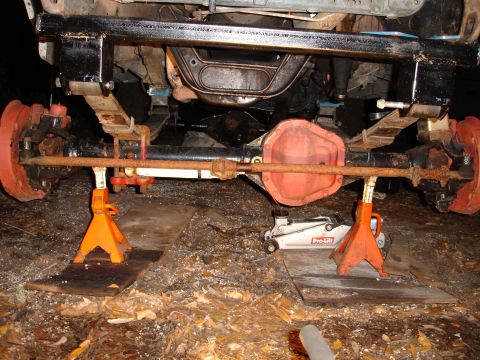 1989 Ford Bronco - Rear axle assembly of a vehicle, supported by jack stands during maintenance or repair.