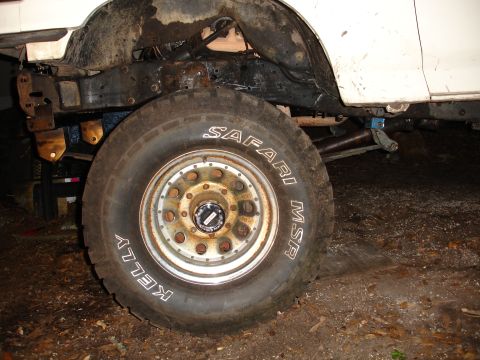1989 Ford Bronco - The vehicle's frame and suspension components are visible around the large tire.