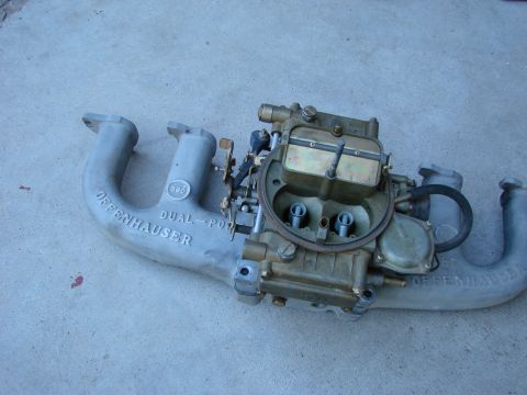 1979 Ford Bronco - Offenhauser dual-port intake manifold and carburetor assembly shown on a concrete surface.