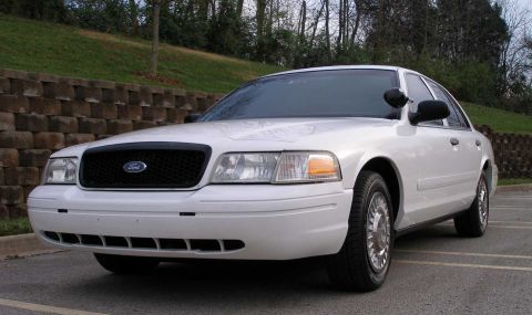 2001 Ford Crown Victoria - A white 2001 Ford Crown Victoria is parked outdoors, showing its front and side profile.