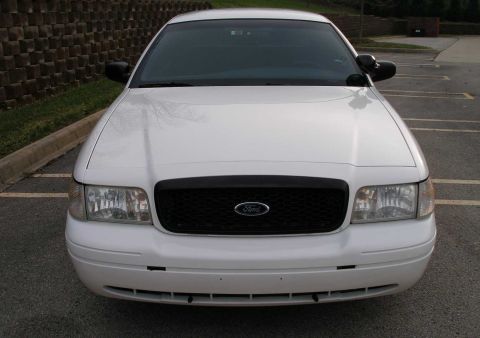 2001 Ford Crown Victoria - Front view of a white Ford Crown Victoria with a black grille and Ford emblem.