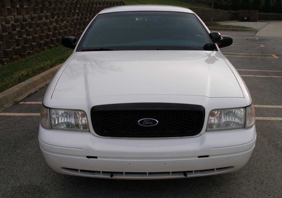 White 2001 Ford Crown Victoria, front view. Black grille with Ford logo