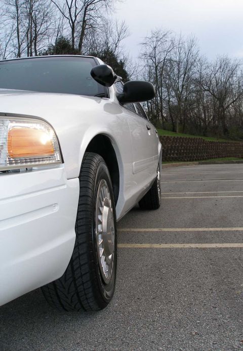 2001 Ford Crown Victoria - A white 2001 Ford Crown Victoria is viewed from the front passenger side in a parking lot.