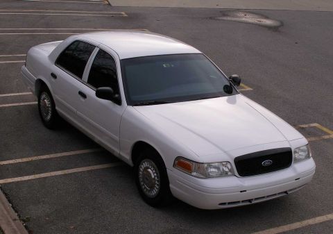 2001 Ford Crown Victoria - White 2001 Ford Crown Victoria sedan parked in a lot with yellow parking lines.