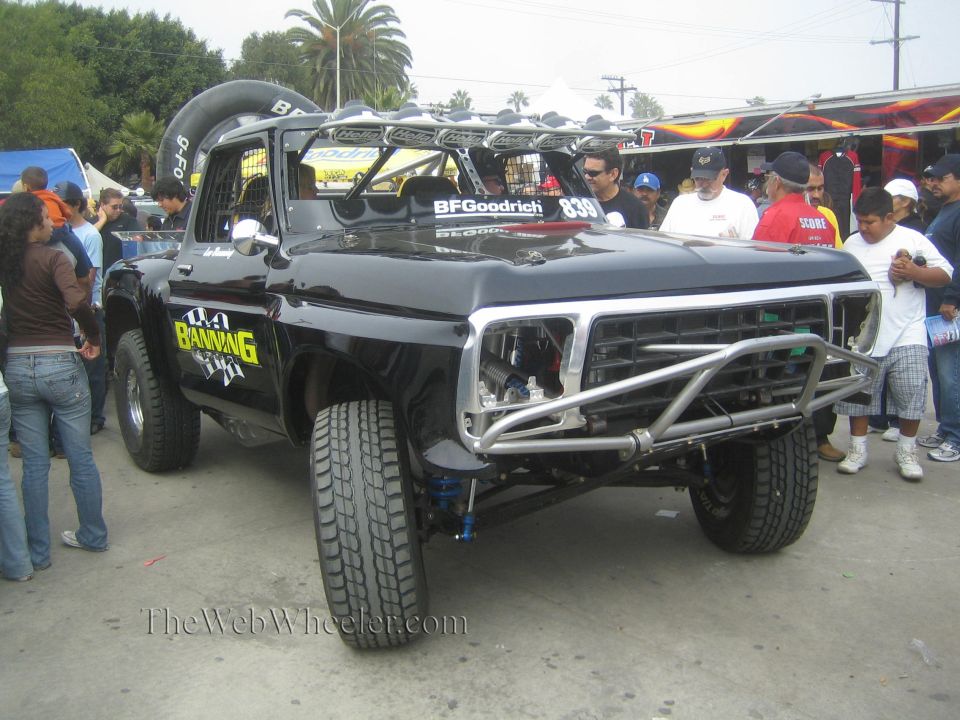 Black classic Ford pickup prerunner with tube bumper at an event