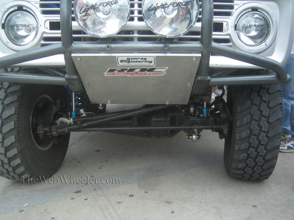 Close-up of off-road truck front suspension, skid plate and lights
