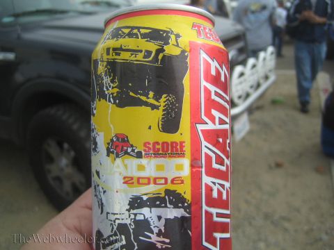 1990 Ford Bronco - hand holds a Tecate beer can printed with off-road race graphics reading 'Score International Baja 2006'.