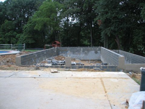 1992 Ford Bronco - A construction site shows a concrete foundation and partially built cinder block walls under a canopy of trees.