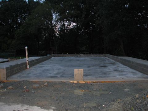 1992 Ford Bronco - Construction site shows a newly poured concrete foundation surrounded by cinder block walls, with trees in the background.