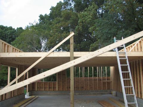 1992 Ford Bronco - Construction of a garage is underway, showing wooden framing and a ladder leaning against the roof structure.