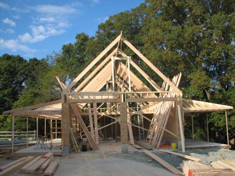 1992 Ford Bronco - The skeletal structure of a house is being built, showing the wooden framework and roof trusses.