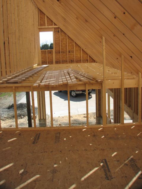 1992 Ford Bronco - A silver SUV is visible through the framing of a house under construction.