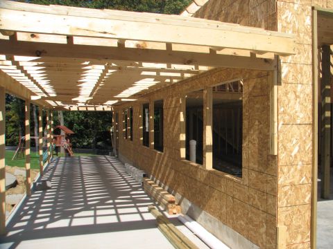 1992 Ford Bronco - Exterior view of a house under construction, showing the framework and OSB sheathing on the walls.