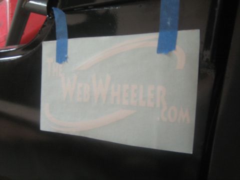 1990 Ford Bronco - TheWebWheeler.com vinyl decal stencil is held to a black vehicle body panel with strips of blue painter's tape.