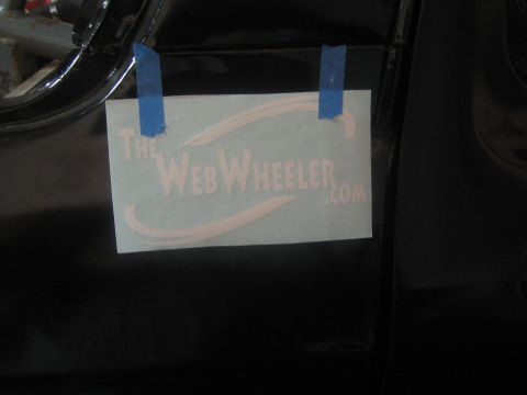 1990 Ford Bronco - TheWebWheeler.com vinyl decal stencil is taped with blue tape to a glossy black vehicle body panel.