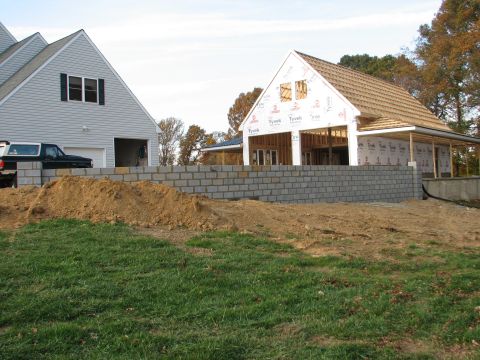 1992 Ford Bronco - A black pickup truck is visible next to a house and garage under construction, with a brick wall in the foreground.