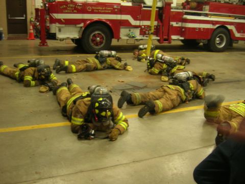1989 Ford Bronco - Firefighters are seen lying on the floor in front of a fire truck inside a station.