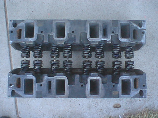 Pair of cast iron engine cylinder heads with valve springs on concrete