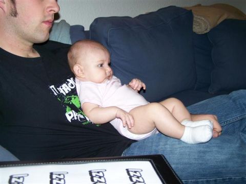1995 Ford Bronco - A man holds a baby while sitting on a couch. Text is visible on the man's shirt.