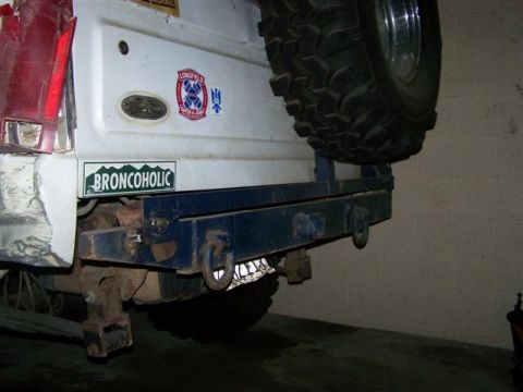 1995 Ford Bronco - The rear of a Ford Bronco is shown, a spare tire and an aftermarket bumper with a 'Broncoholic' sticker.