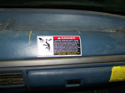 1995 Ford Bronco - A "DANGER LAWYER OPPORTUNITY ZONE" sticker is affixed to the dashboard of a vehicle.