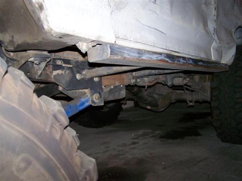 1995 Ford Bronco - Close-up view of the undercarriage and suspension system of a vehicle, large off-road tires.