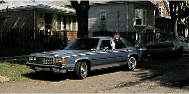 Light blue Ford LTD Crown Victoria sedan parked on a residential street, front three-quarter view