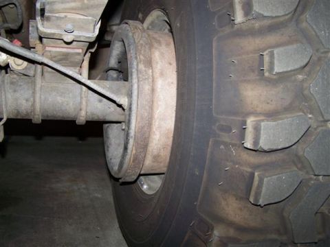 1995 Ford Bronco - This image shows a close-up view of a vehicle's rear axle, brake drum, and a large tire with aggressive tread.
