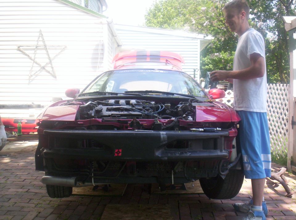 1997 Ford Probe front view, hood open, bumper removed, engine exposed. Man standing next to it