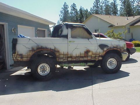 1989 Ford Bronco - This pickup truck features a unique painted design simulating rust and cracks along its side.