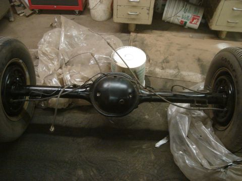 1992 Ford Crown Victoria - A rear axle assembly with wheels is shown, covered in plastic, in what appears to be a workshop.