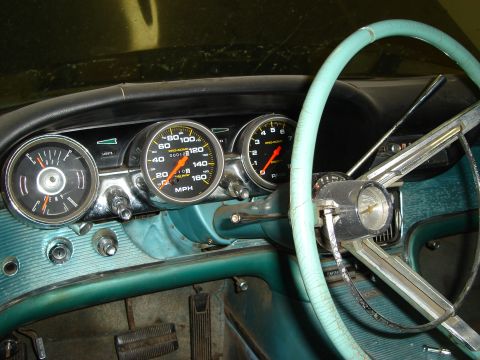 1992 Ford Crown Victoria - The interior of a vintage car shows a turquoise dashboard with two prominent gauges and a light blue steering wheel.