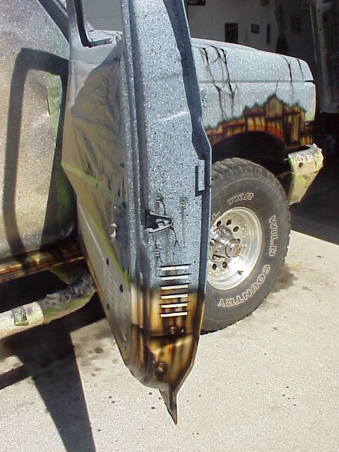 1989 Ford Bronco - A Ford Bronco's door is open, revealing its interior and exterior, while the fender displays a mural.