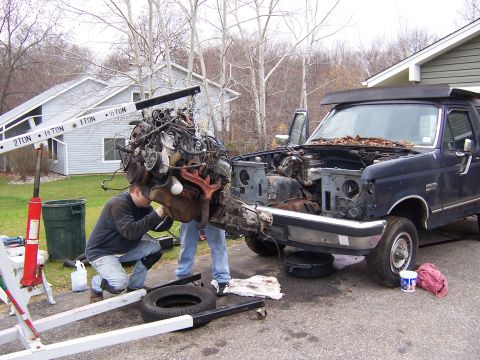 1987 Ford Bronco - A 1987 Ford Bronco is shown with its engine being lifted out by a crane.