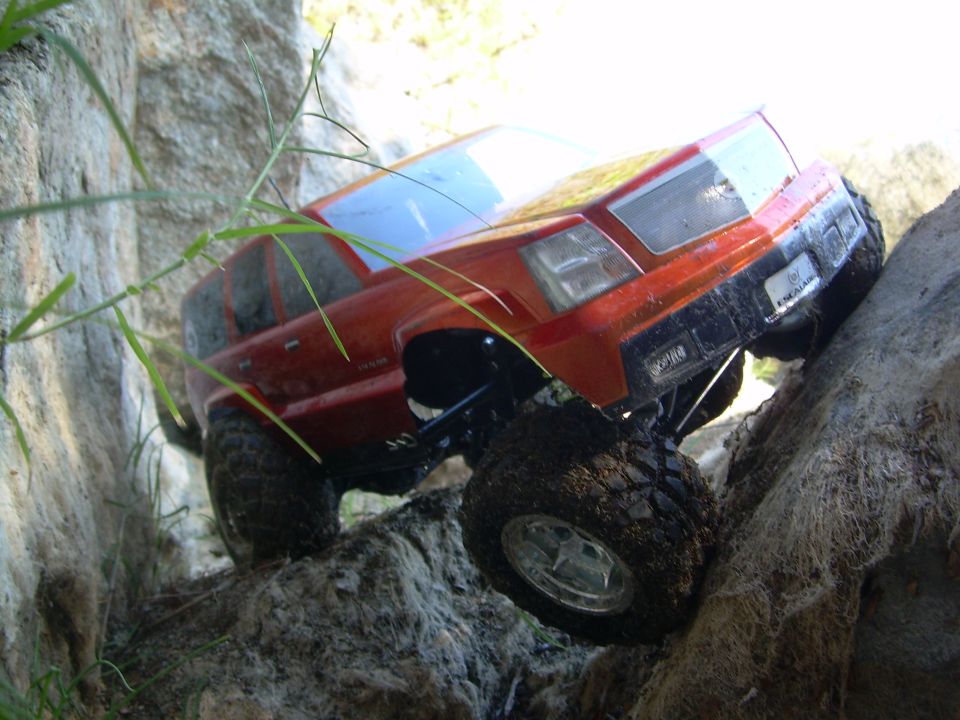 Orange RC crawler truck climbing rocks