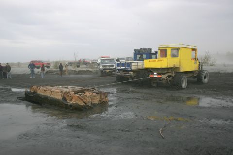 2003 Jeep TJ - Multiple vehicles are involved in towing a submerged, wrecked vehicle out of the mud.