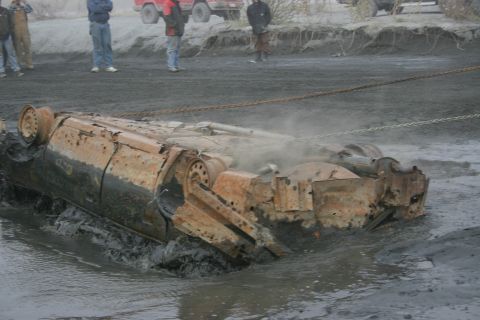 2003 Jeep TJ - Vehicle stuck in mud, being recovered with chains.