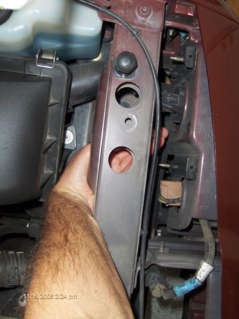 2004 Ford Crown Victoria - Removing a car part near the headlight assembly.