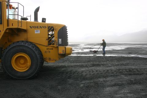 2003 Jeep TJ - Volvo wheel loader on a beach with a person working in the background.