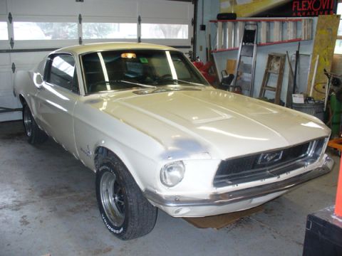 1968 Ford Mustang - A white 1967 Ford Mustang sits in a garage with the hood up, showing some primer work.