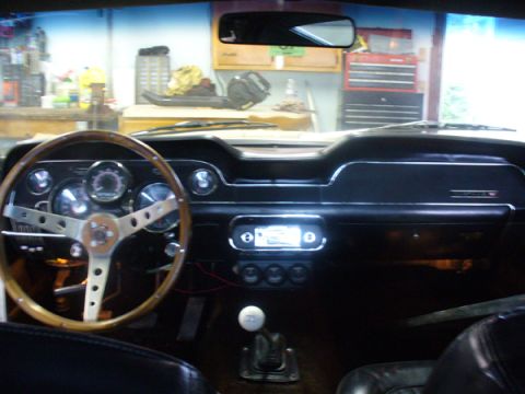 1968 Ford Mustang - The interior of a 1968 Ford Mustang showcases its classic dashboard, steering wheel, and shifter.