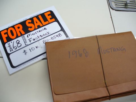 1968 Ford Mustang - A 'For Sale' sign and a folder with '1968 Mustang' written on it are displayed.