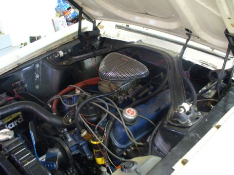 1968 Ford Mustang - The engine bay of a vehicle, showing the V8 engine components and wiring.